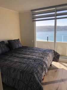 a bedroom with a bed with a view of the ocean at Condominio costazul La Herradura in Coquimbo