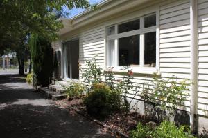 a white house with a window and some plants at 44 Scarborough Tce in Hanmer Springs