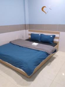 a bed with blue sheets and blue pillows in a room at NHÀ NGHỈ ANA in Cái Răng