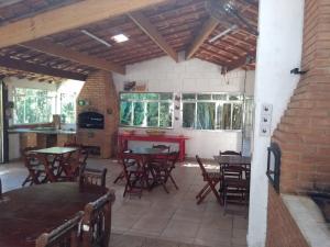 a patio with tables and chairs in a building at Chacara Branca de Neve in Biritiba-Mirim