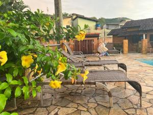 een groep banken naast een zwembad bij Camburi Chalés in Camburi