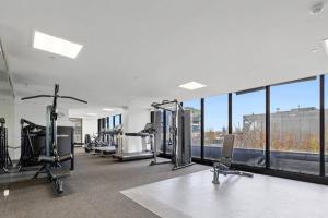 een fitnessruimte met loopbanden, cardio-apparatuur en ramen bij Modern 1 Bdr APT in South Yarra (TF50424) in Melbourne