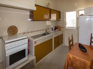 a kitchen with a stove and a sink and a refrigerator at Alojamento Mareta in Sagres