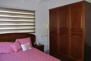 1 dormitorio con 1 cama y un gran armario de madera en Villa Esther two private rooms in a Vacation Villa near Blue Bay golf and beach resort en Willemstad
