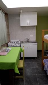 uma cozinha com um fogão, um lavatório e uma mesa em apartamento los lobos em Mar del Plata