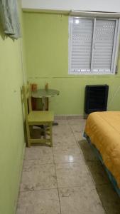 Cette chambre comprend une table, une chaise et un lit. dans l'établissement apartamento los lobos, à Mar del Plata
