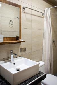 a bathroom with a white sink and a shower at Rockrivers MachuPicchu in Machu Picchu