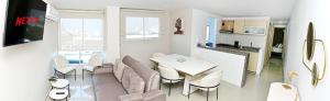 een woonkamer met een tafel en stoelen en een keuken bij Excelente ubicación y cómodo apto, perfecto para ti! in Barranquilla