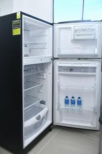 an open refrigerator with bottles of water in it at Excelente ubicación y cómodo apto, perfecto para ti! in Barranquilla