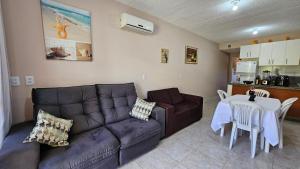 ein Wohnzimmer mit einem Sofa und einem Tisch in der Unterkunft Arembepe - Aldeia St Sebastien Casa Mar 10 in Camaçari