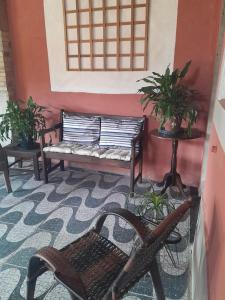 une salle avec deux bancs et une table avec des plantes dans l'établissement Meu Quarto no Rio de Janeiro, à Duque de Caxias