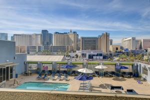a pool with umbrellas and chairs and a city skyline at Princess Suite Platinum Hotel in Las Vegas