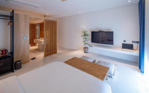 sypialnia z łóżkiem i telewizorem oraz łazienka w obiekcie Hotel Barahan Jeonju w mieście Jeonju
