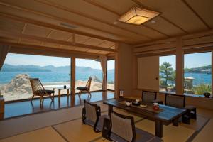 uma sala de jantar com vista para o oceano em 夕景の宿　海のゆりかご　萩小町 em Hagi