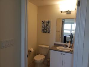 a bathroom with a toilet and a sink and a mirror at Luxurious Condo Apartment 1BR-1BA-1Office free parking in Brampton +63 photos