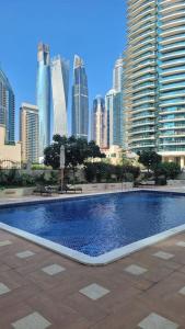 a large swimming pool in a city with tall buildings at Full Marina View 2BR Luxury Apartment in Dubai