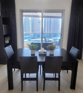 a dining room with a table and chairs and a window at Full Marina View 2BR Luxury Apartment in Dubai