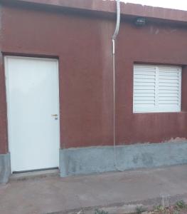 two white doors on a red building with at El Descanso in Villa Unión