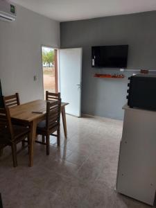 a dining room with a table and chairs and a television at El Descanso in Villa Unión