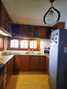 uma cozinha com armários de madeira e um frigorífico branco em Casa a 2 cuadras de la playa em Necochea