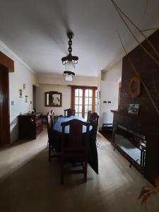a dining room with a table and a piano at Casa a 2 cuadras de la playa in Necochea