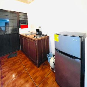 a kitchen with a stainless steel refrigerator and a wooden floor at Bonito departamento y centrico in Lázaro Cárdenas