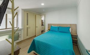 una camera con un letto blu e una finestra di Casa Tartaruga a Cartagena de Indias