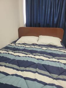 - un lit bleu et blanc avec 2 oreillers dans l'établissement HOTEL K'RITAS K'STRO, à Ica