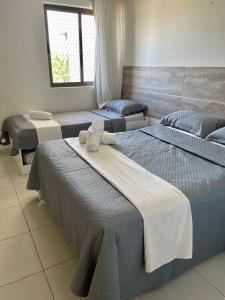 una stanza con tre letti con asciugamani sopra di Flat Beira Mar - Carneiros Beach Resort a Tamandaré Altre 37 foto