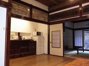 cocina con nevera blanca en una habitación en （一棟貸切）町家体験ゲストハウス「ほんまちの家」〜高岡市の伝統的な古民家～, en Yokota