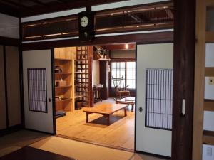 una puerta abierta en una habitación con una mesa en （一棟貸切）町家体験ゲストハウス「ほんまちの家」〜高岡市の伝統的な古民家～, en Yokota