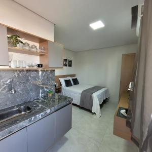 uma cozinha e um quarto com uma cama num quarto em Apartamento mobilhado,5 minutos do aeroporto em Marabá