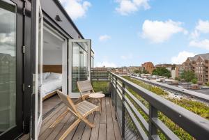 a room with a bed and two chairs on a balcony at Hala DC in Washington