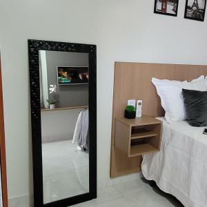 um quarto com um espelho ao lado de uma cama em Apartamento mobilhado,5 minutos do aeroporto em Marabá