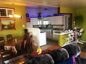 a living room and kitchen with a table and a couch at Gîte du Moulin in L'Isle-aux-Coudres