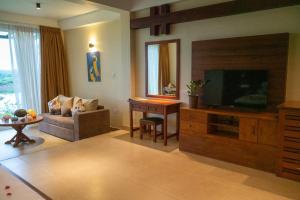 een woonkamer met een televisie en een bank bij Birds Resort Hambantota in Hambantota