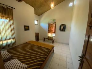 a bedroom with a bed in a room with a window at Balinese Villa Syariah in Sekupang