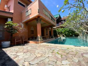 a house with a swimming pool next to a building at Balinese Villa Syariah in Sekupang