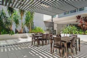 a patio with a table and chairs under a pergola at 37F Brisbane CBD Apartment with City Views and Pool in Brisbane