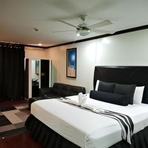 una camera con un grande letto e un ventilatore a soffitto di Grand Central Hotel a Angeles