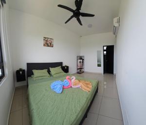 1 dormitorio con 1 cama con toallas y ventilador en Sky Garden HomeStay, Presint 15 Putrajaya, en Putrajaya