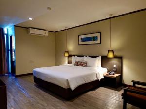 - une chambre avec un grand lit blanc dans l'établissement Bangkok Inter Place, à Bangkok