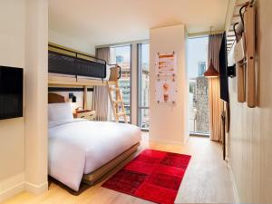 a bedroom with a white bed and a red rug at Moxy Seoul Myeongdong in Seoul