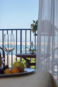 a person sitting at a table with a bowl of fruit at Hotel Al Faro in Licata