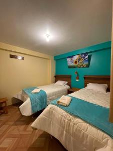 twee bedden in een kamer met blauwe muren bij casa marfil tourist house in Cuzco