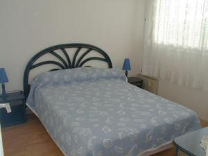 1 dormitorio con 1 cama con edredón azul en Appartement Arcachon, 3 pièces, 6 personnes - FR-1-374-39, en Arcachon