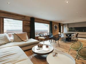 a living room with a couch and tables and chairs at Beau 4 pièces rénové au coeur du village, proche ski et loisirs - FR-1-304-206 in La Clusaz