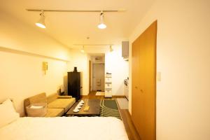 a bedroom with a bed and a couch in a room at 渋谷駅から6分/FREEWiFi/貸切マンション一室/33㎡/可做饭/中国語&韓国語&英語 in Tokyo