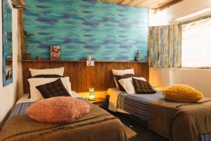 2 camas en una habitación con un cuadro en la pared en Oásis - charme e aconchego, perto de tudo!, en Alto Paraíso de Goiás
