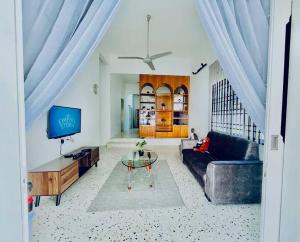 ein Wohnzimmer mit einem Sofa und einem TV in der Unterkunft Gioia2Home 5 mins to Taiping/Kamunting in Taiping